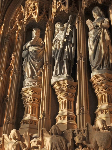 Statues inside Westminster Abbey, London, highlighting intricate Gothic architecture.