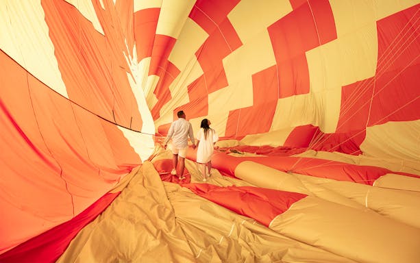 Couple inside a hot air balloon preparing for a luxury flight experience.