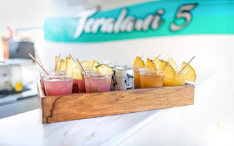 Drinks with pineapple slices on a tray aboard a luxury catamaran in Lahaina.