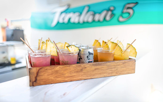 Drinks with pineapple slices on a tray aboard a luxury catamaran in Lahaina.