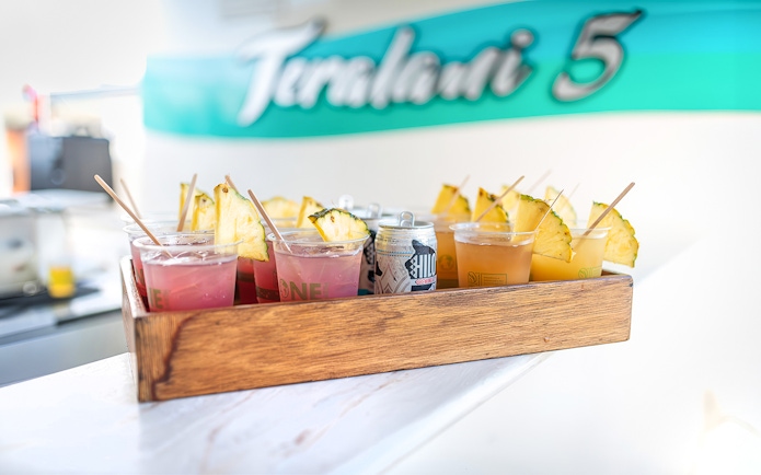 Drinks with pineapple slices on a tray aboard a luxury catamaran in Lahaina.