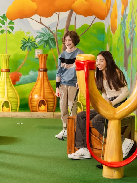 Group playing mini golf at Angry Birds Mini Golf, American Dream, with colorful slingshot obstacles.