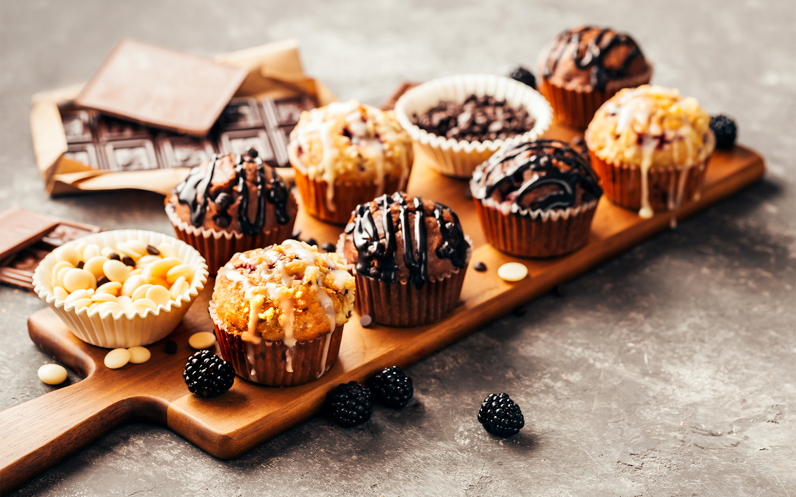 Assorted chocolate muffins and berries on a wooden board at Disneyland Paris restaurant.