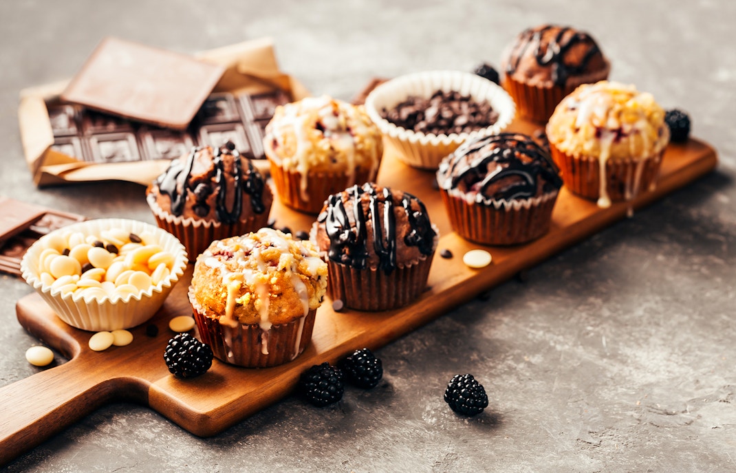 Assorted chocolate muffins and berries on a wooden board at Disneyland Paris restaurant.