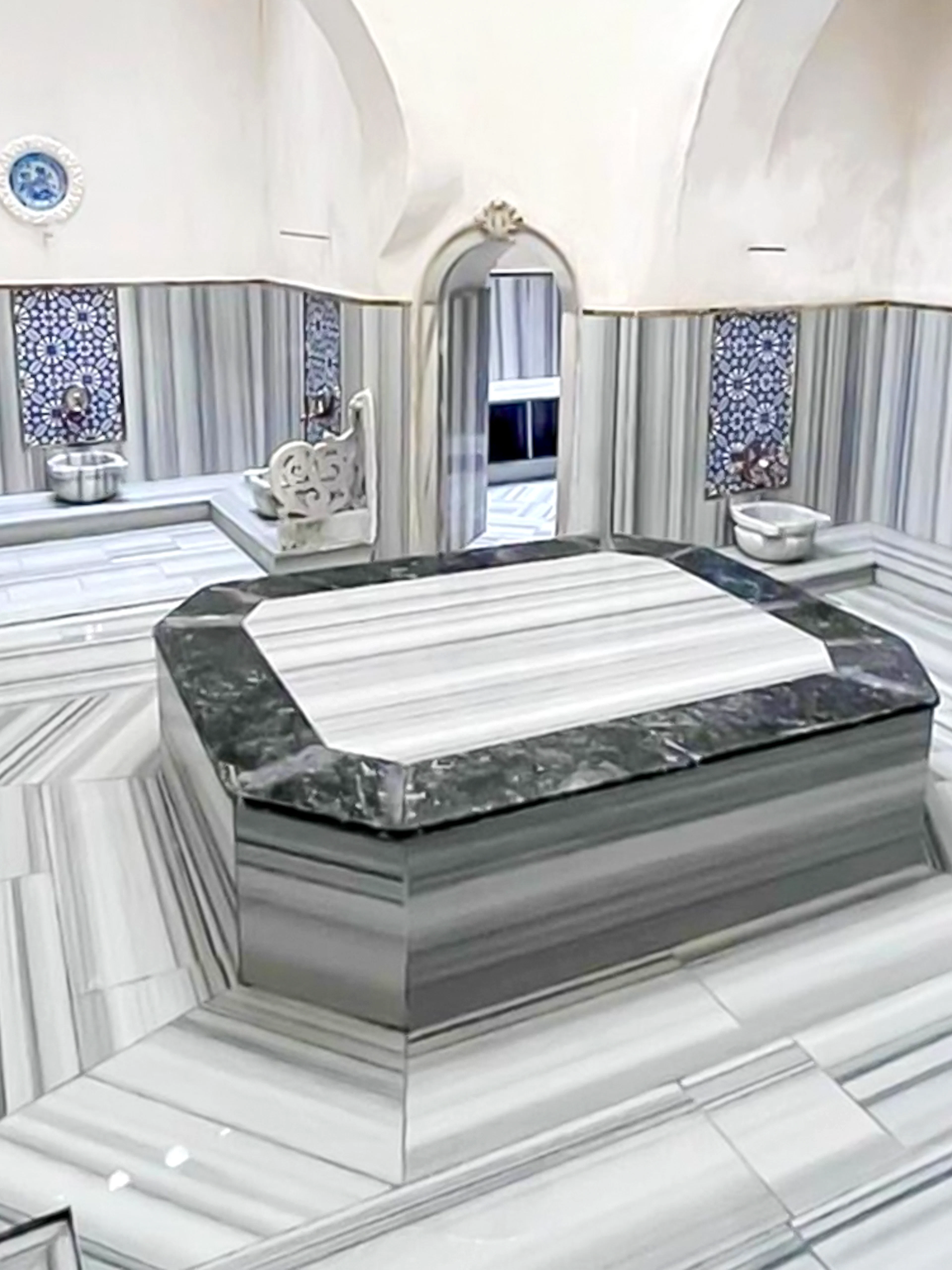 Interior of Sifa Hamam with marble seating and decorative tiles.