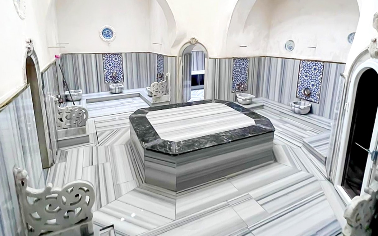 Interior of Sifa Hamam with marble seating and decorative tiles.