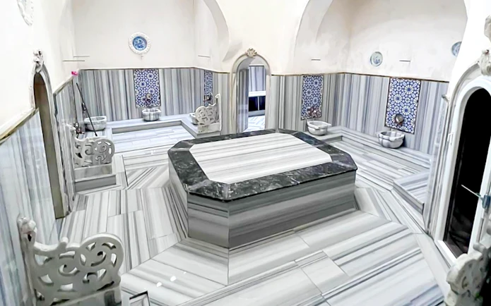 Interior of Sifa Hamam with marble seating and decorative tiles.