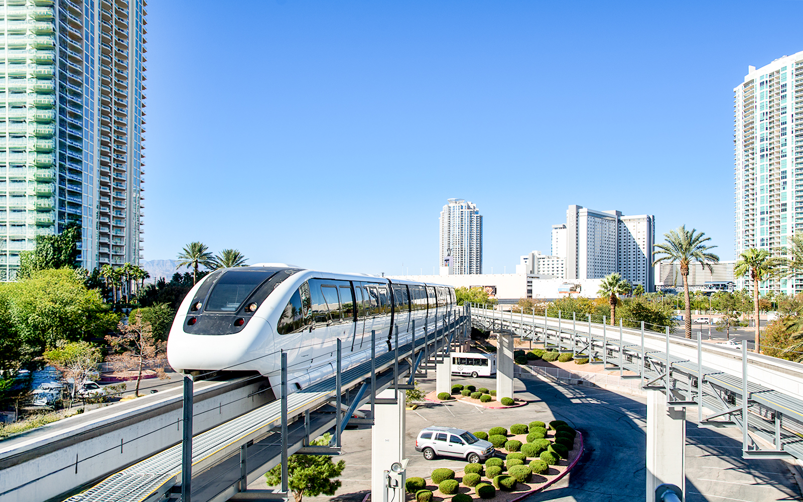 Las Vegas monorail passing through cityscape with tall buildings.