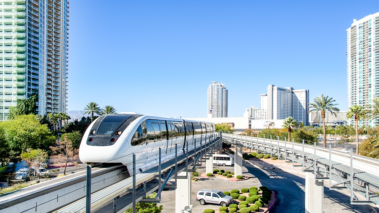 Las Vegas monorail passing through cityscape with tall buildings.