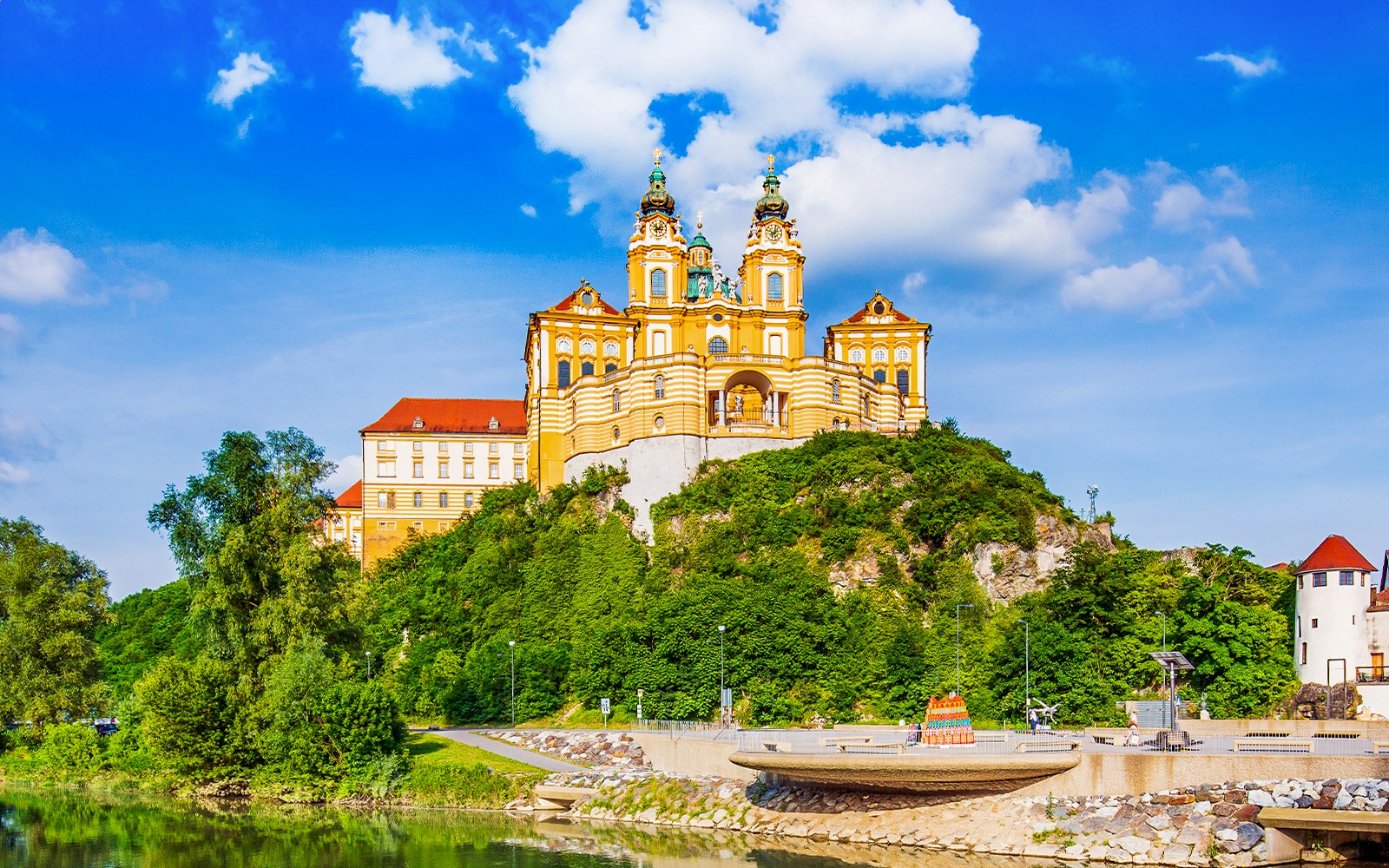 Melk Abbey exterior with baroque architecture in Vienna, Austria, overlooking the Danube River.