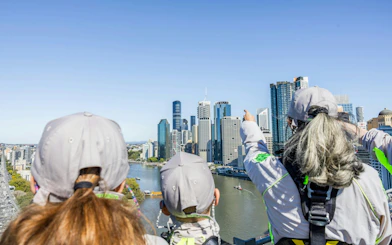 Climbers on Story Bridge Adventure Climb overlooking Brisbane skyline.