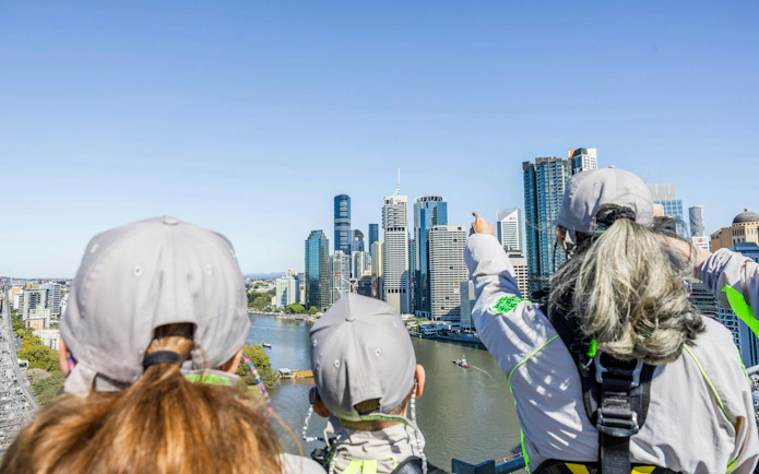 Climbers on Story Bridge Adventure Climb overlooking Brisbane skyline.