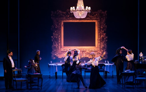 Theater performance in Leopoldstadt with actors dancing under a chandelier.