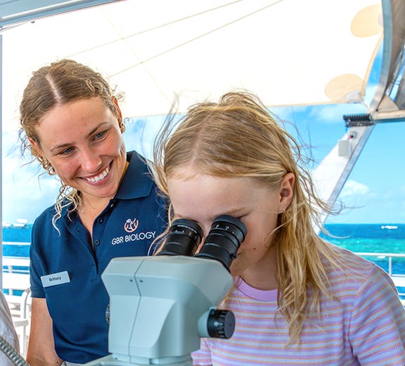 Child using microscope on Cairns school holiday tour.