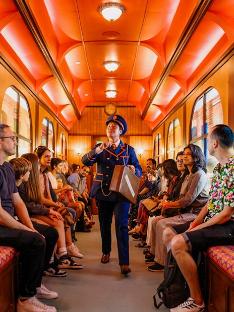 Children on a train during The Paddington Bear Experience in London, enjoying interactive storytelling.