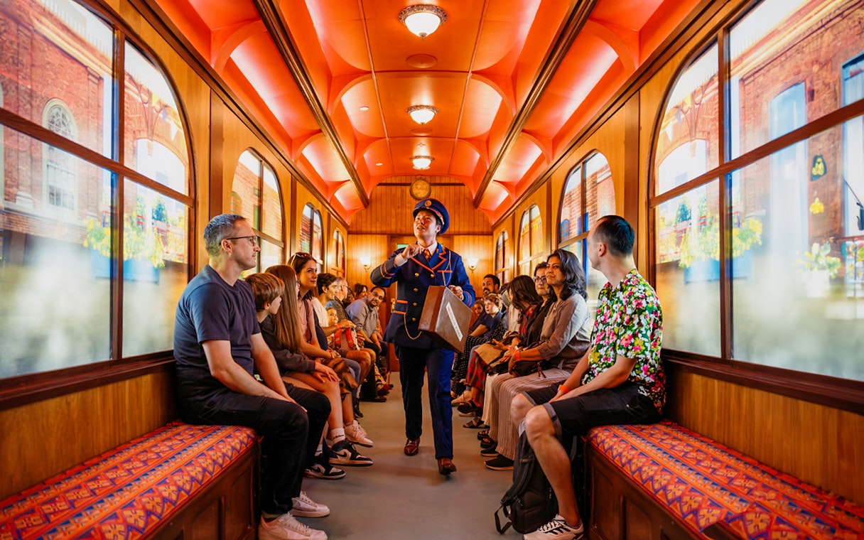 Children on a train during The Paddington Bear Experience in London, enjoying interactive storytelling.