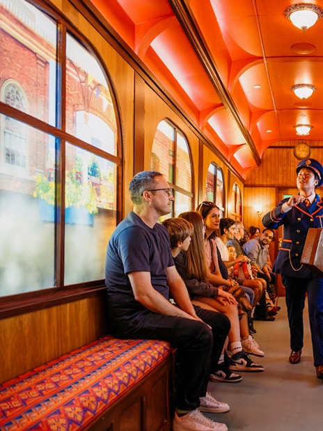Children on a train during The Paddington Bear Experience in London, enjoying interactive storytelling.