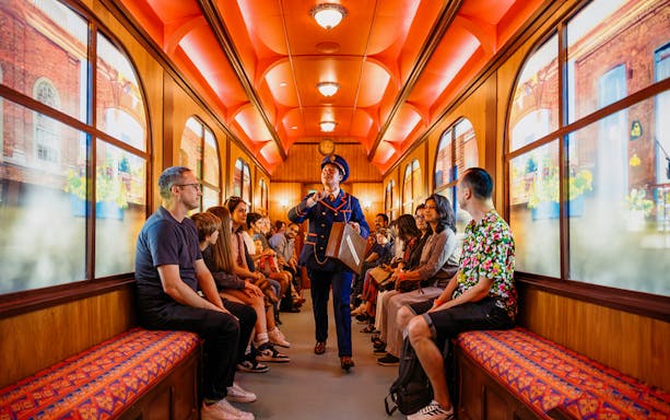 Children on a train during The Paddington Bear Experience in London, enjoying interactive storytelling.