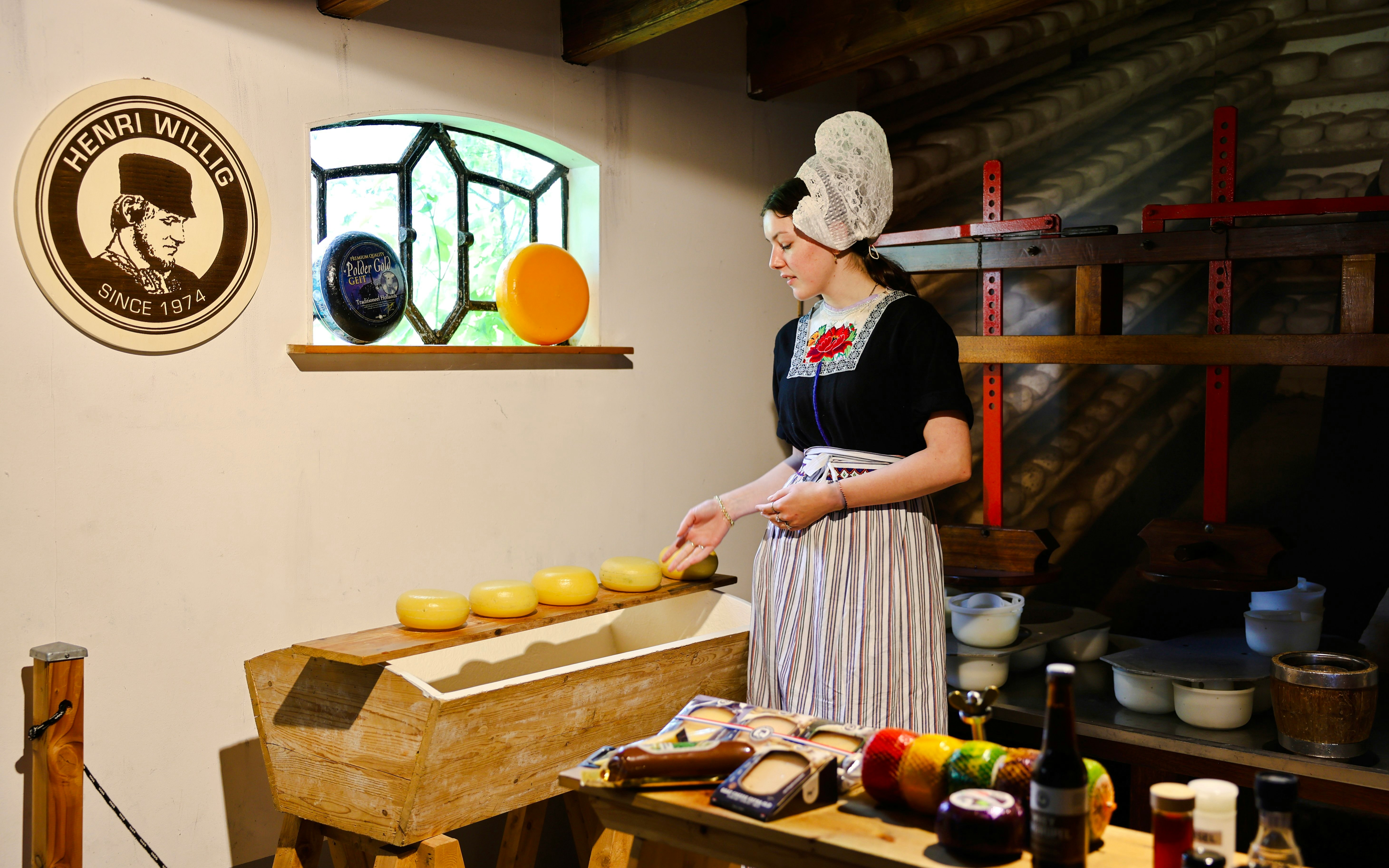 Henri Willig Cheese Farm interior with guide showcasing cheese display.