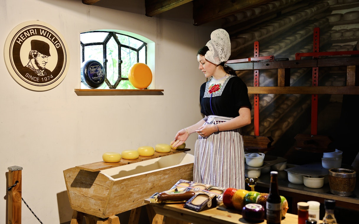 Henri Willig Cheese Farm interior with guide showcasing cheese display.