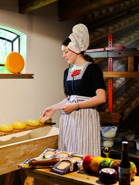 Henri Willig Cheese Farm interior with guide showcasing cheese display.