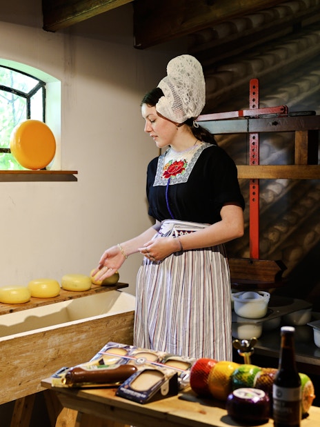 Henri Willig Cheese Farm interior with guide showcasing cheese display.