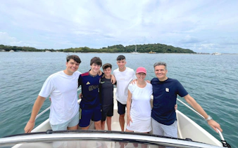 Group on a speedboat with Sentosa coastline in the background, Singapore.
