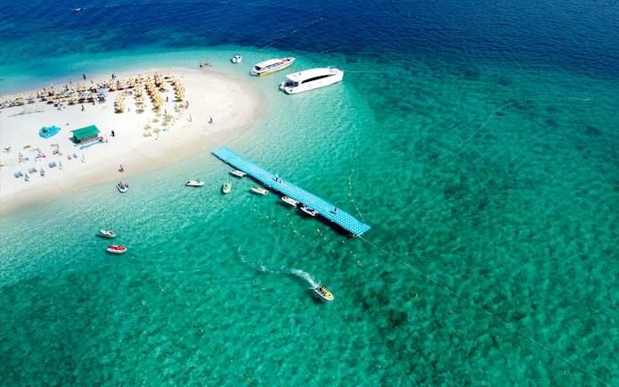 Aerial view of Khai Island beach with boats and pier, Thailand.