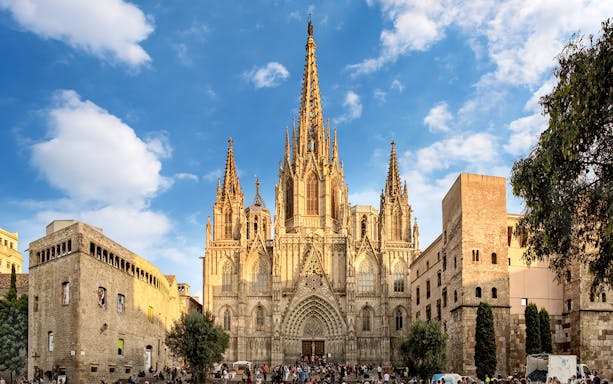 Cathedral of Barcelona facade with tourists on a guided tour.