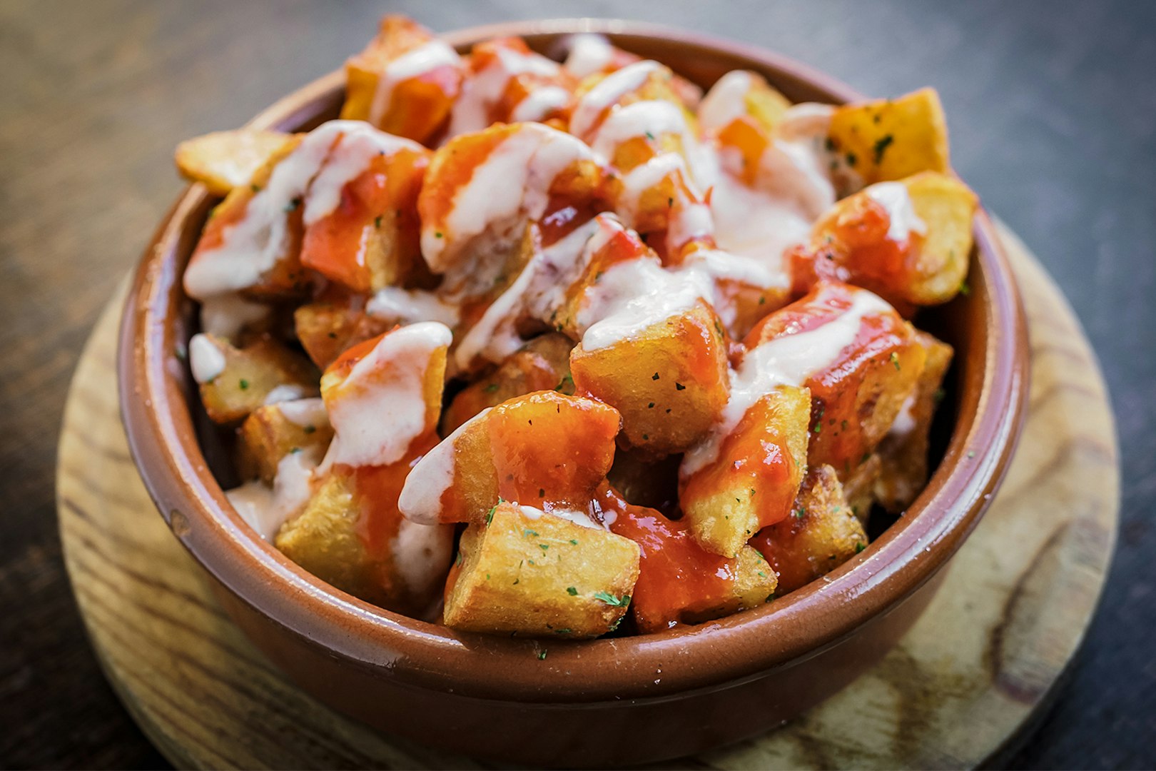 Patatas Bravas served in a clay dish on the Tapas Walking Tour in Triana.
