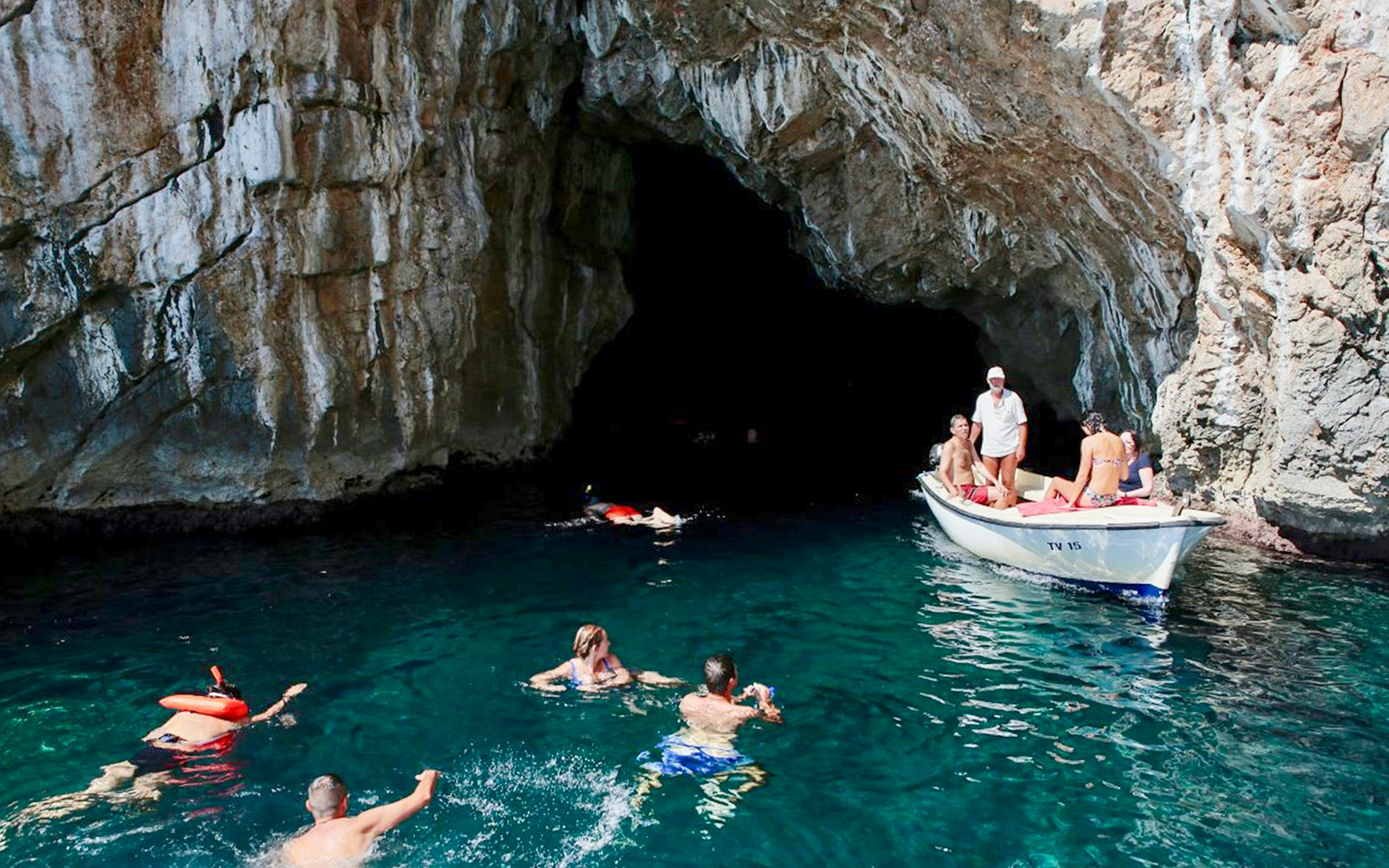 Swimmers and a boat near the entrance of the Blue Cave, Kotor.