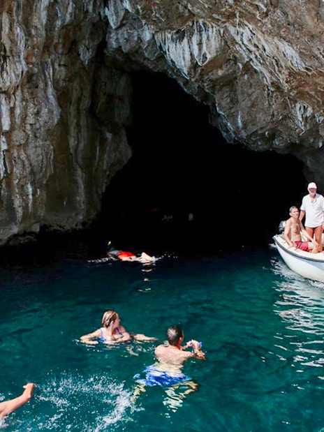 Swimmers and a boat near the entrance of the Blue Cave, Kotor.