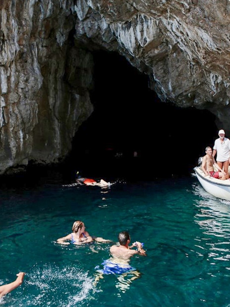 Swimmers and a boat near the entrance of the Blue Cave, Kotor.