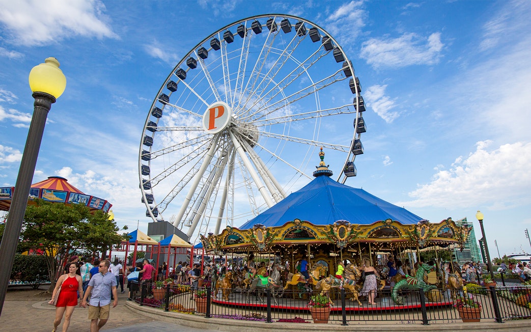 Ferris wheel and carousel at Navy Pier, Chicago, with visitors enjoying the attractions.