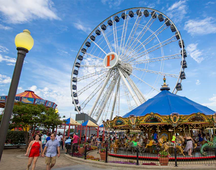Ferris wheel and carousel at Navy Pier, Chicago, with visitors enjoying the attractions.