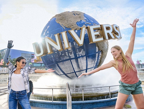 Guests posing in front of the Universal globe and fountain at Universal Studios Orlando.