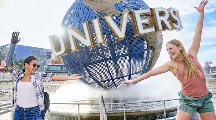 Guests posing in front of the Universal globe and fountain at Universal Studios Orlando.