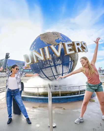Guests posing in front of the Universal globe and fountain at Universal Studios Orlando.