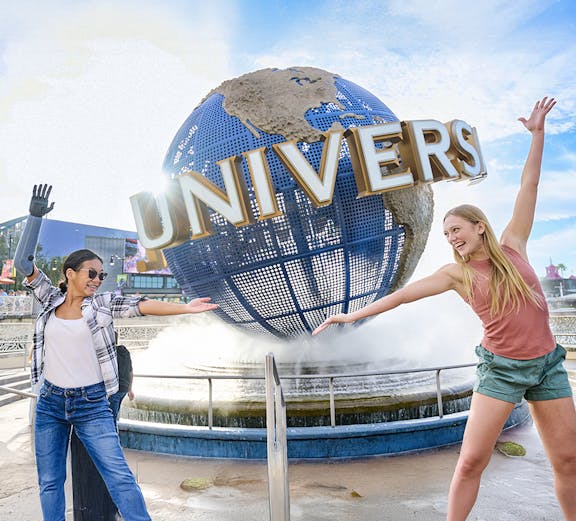Guests posing in front of the Universal globe and fountain at Universal Studios Orlando.