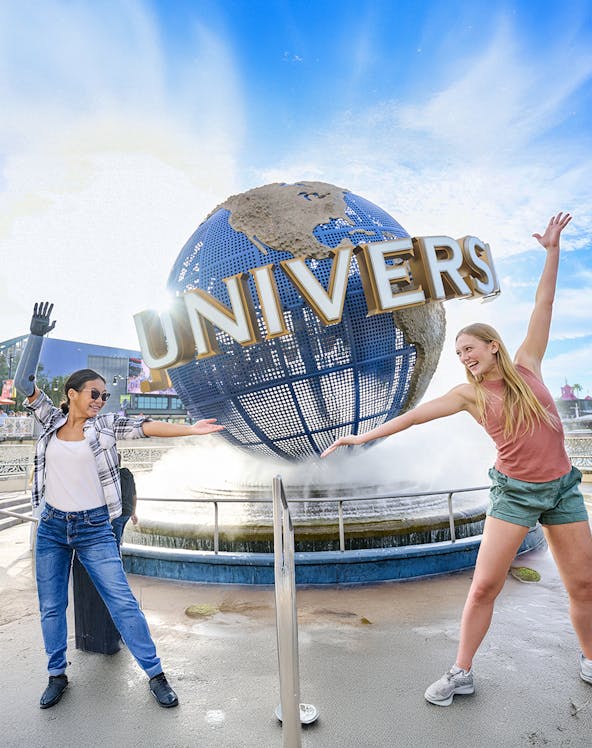 Guests posing in front of the Universal globe and fountain at Universal Studios Orlando.