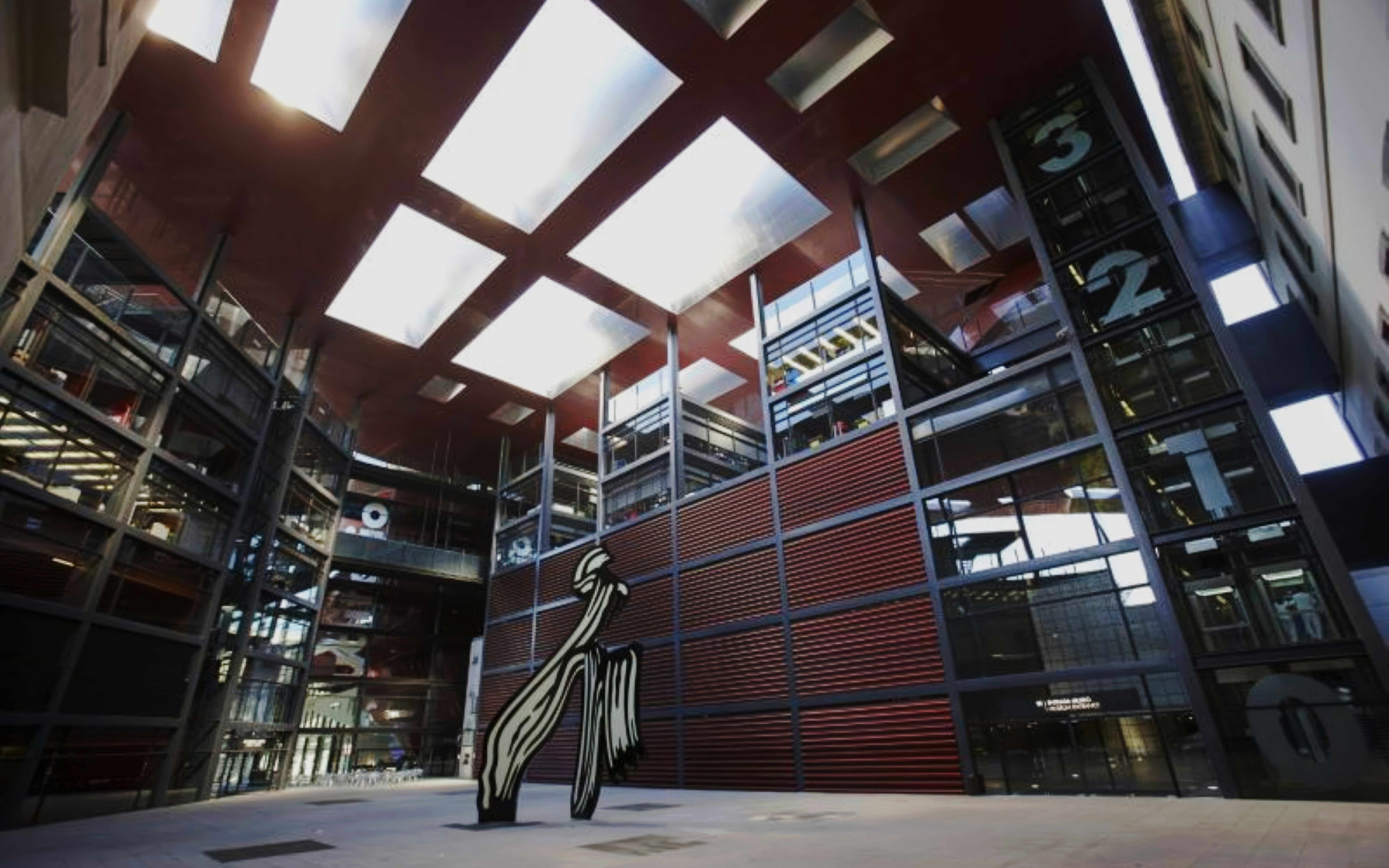 Reina Sofia Museum atrium with modern sculpture and glass architecture.