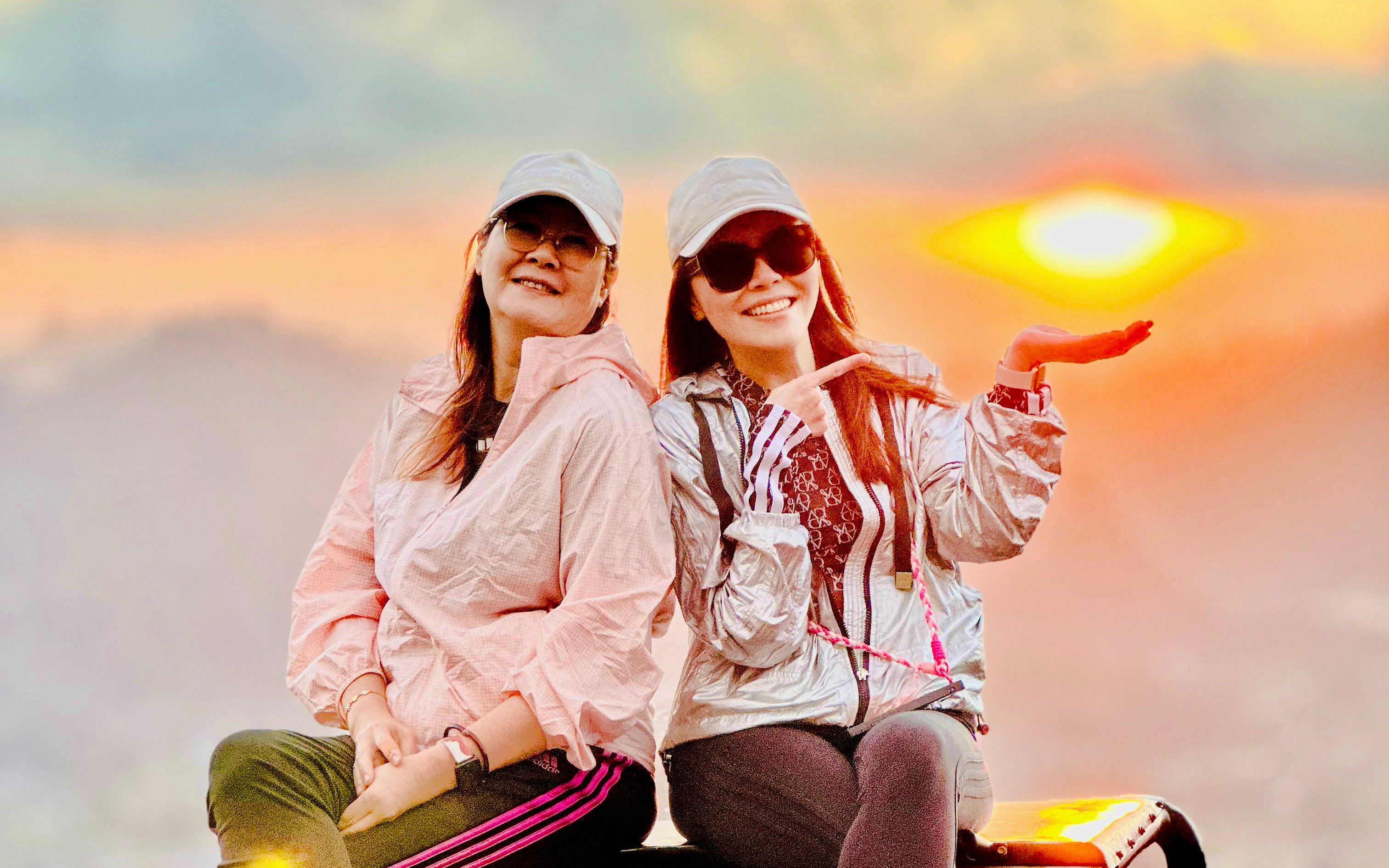 Friends sitting on a jeep at sunrise near Mount Batur, Bali.