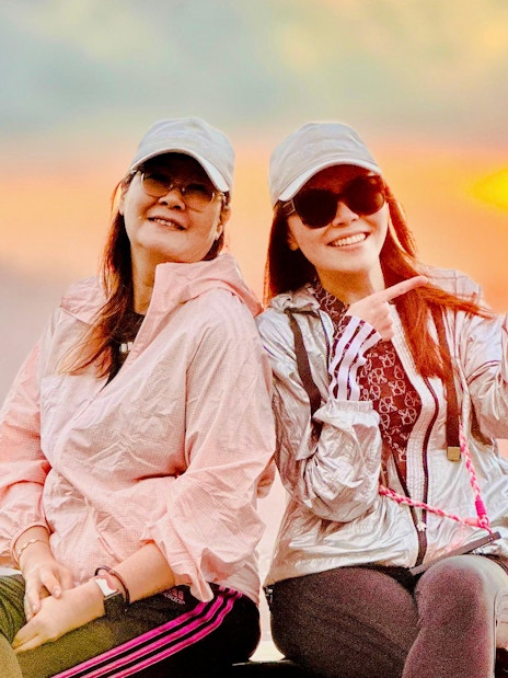 Friends sitting on a jeep at sunrise near Mount Batur, Bali.