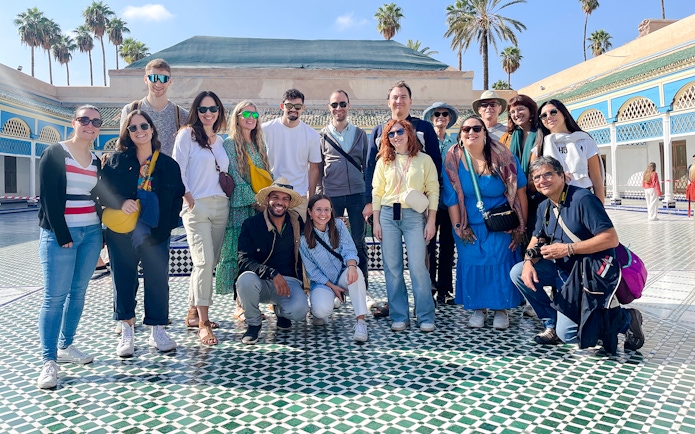Group of tourists at Bahia Palace courtyard in Marrakech, Morocco.