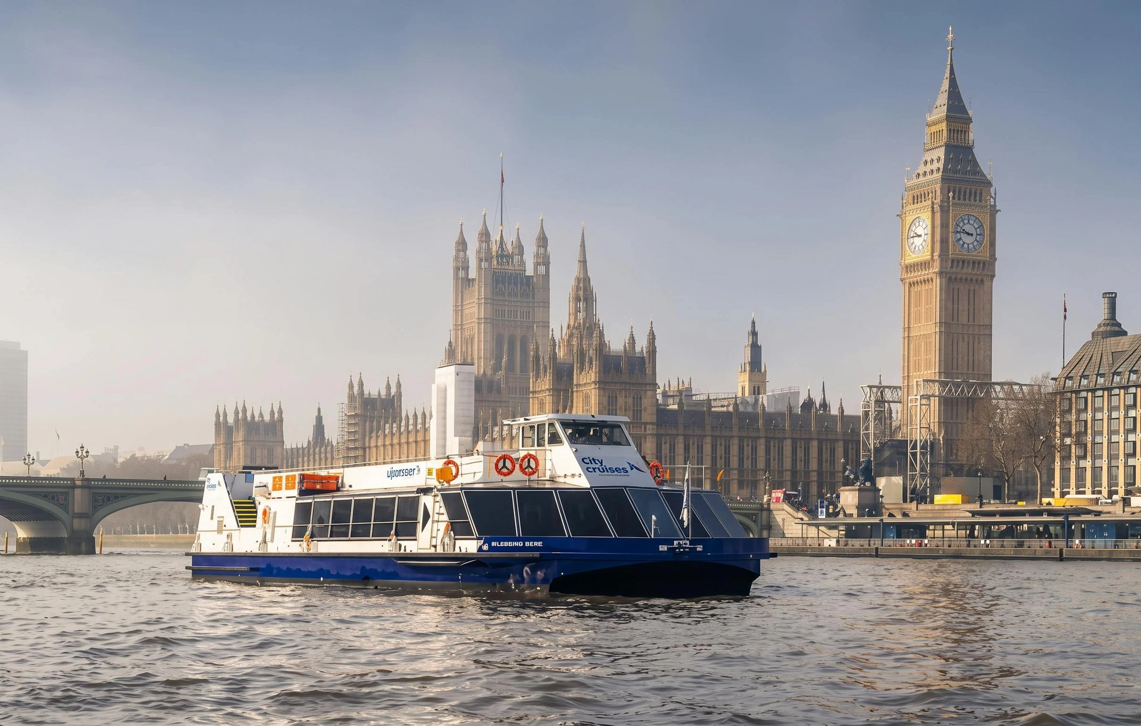 City cruise boat on the Thames with Big Ben and Houses of Parliament in London.