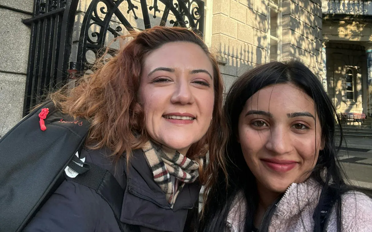 Two people smiling in front of a historic building in Dublin during a ghost hunt city exploration game.
