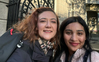 Two people smiling in front of a historic building in Dublin during a ghost hunt city exploration game.
