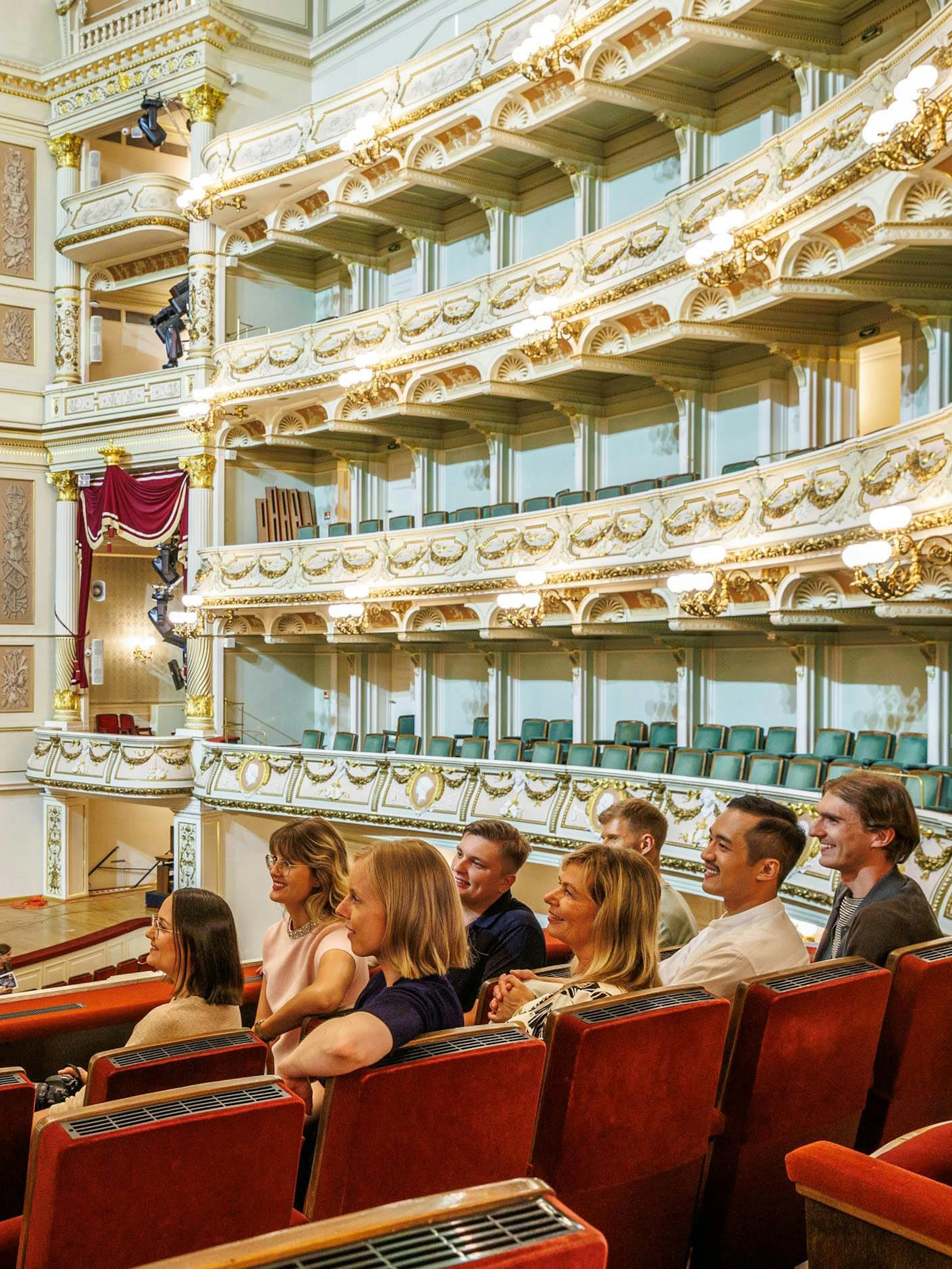Tour guide explaining the interior of Semper Opera House to visitors.