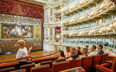 Tour guide explaining the interior of Semper Opera House to visitors.