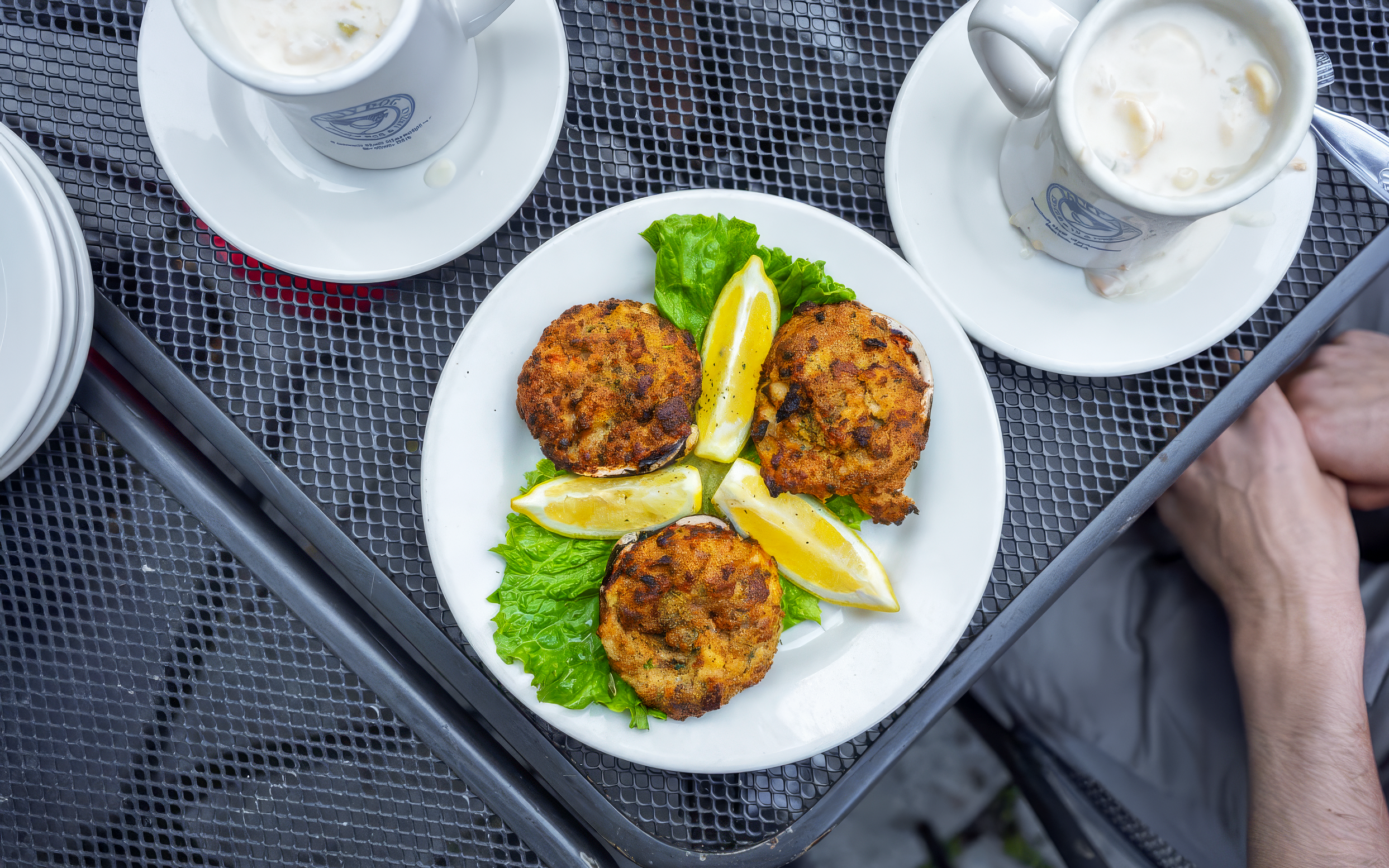 Crab cakes with lemon wedges and lettuce on a plate.